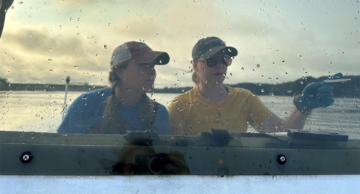Sisters Krystin Ward, left, and Laura Brown navigate a boat from Great Bay Estuary toward the restoration site near Nannie Island.