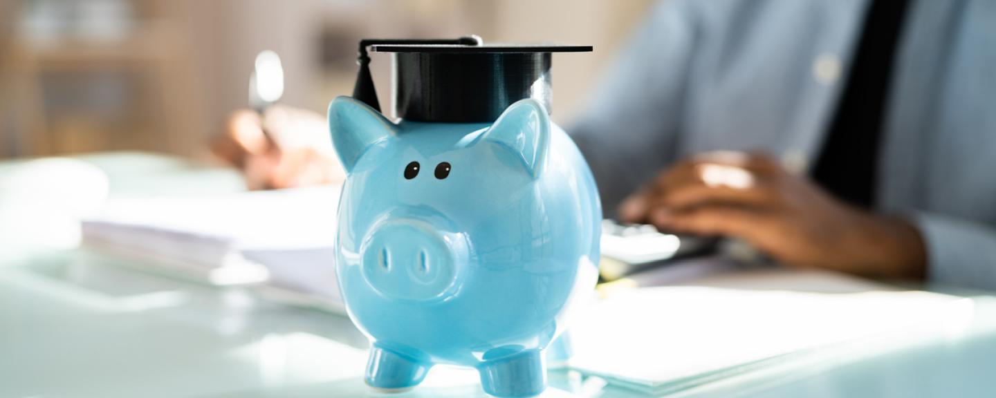 piggy bank on table with grad cap