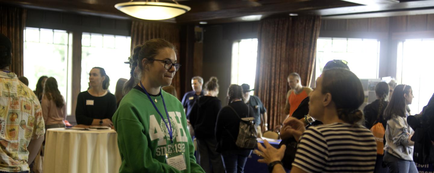 Two women engage in conversation in a convention center
