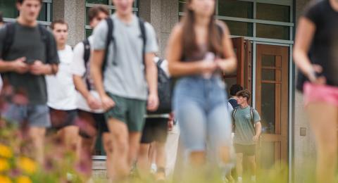 two college students walking in from of the UNH Paul College of Business and Economics