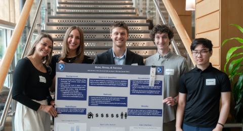 Paul College students present their research poster exploring whether paying high rent prices impacts academic success.