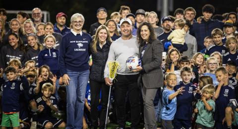 UNH President Elizabeth Chilton, Greg and Corinna Tucker and UNH Director of Athletics Allison Rich surrounded by local youth athletic association members on Tucker Field