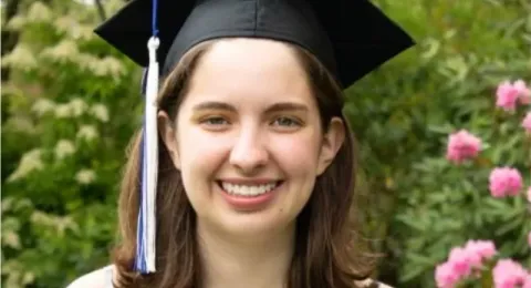 UNH genetics doctoral student Olivia Williams poses in her graduation cap