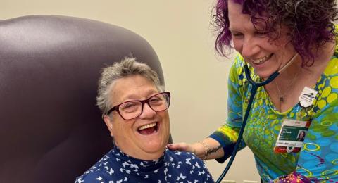 A doctor using a stethoscope on a female patient