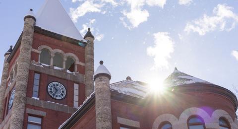 Sun glints off the top of Thompson Hall after a dusting of snow