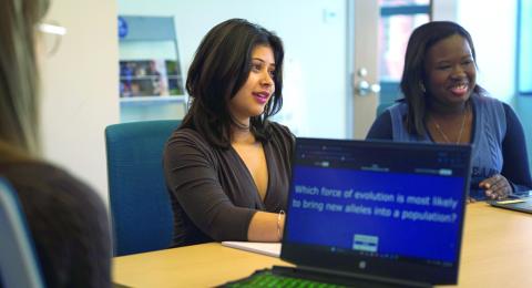 Three students sitting at a desk with a computer