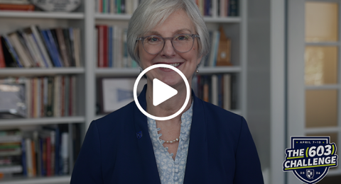 Video screengrab of UNH President Elizabeth Chilton smiling while standing in front of a bookcase