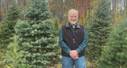 image of Glenn Coppelman standing next to a pine tree 