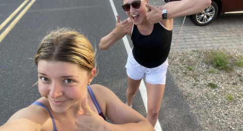 two people smiling with thumbs up