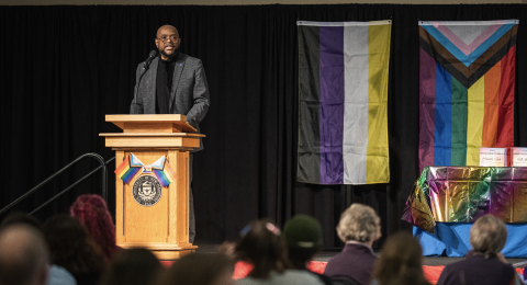 man standing at a podium on a stage in front of a group of people