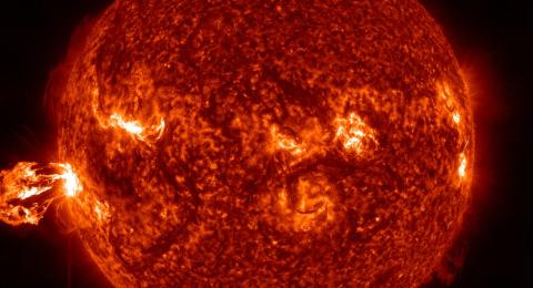 Visualization of the sun's surface with an eruption on the left side.