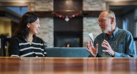 BoRin Kim, associate professor of social work, speaks with a resident at RiverWoods Durham