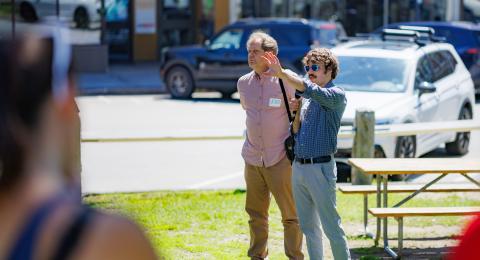 A man uses a loudpseaker to adress a crowd in an outdoor space