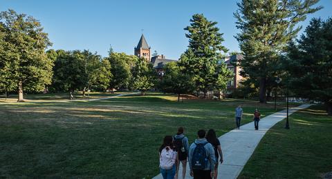 Students walk a concrete path on the UNH campus