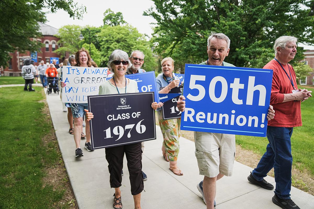 UNH alumni walk in a parade during reunion weekend