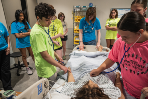 High school students practice on a mannequin at the UNH Health Sciences Simulation Center