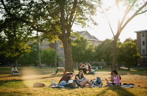 UNH students hanging out outdoors on campus