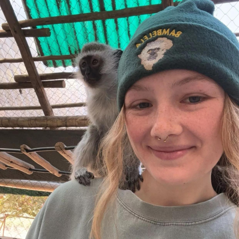 UNH student Morgan Breen with monkey on her shoulder in South Africa where she is conducting research this summer.