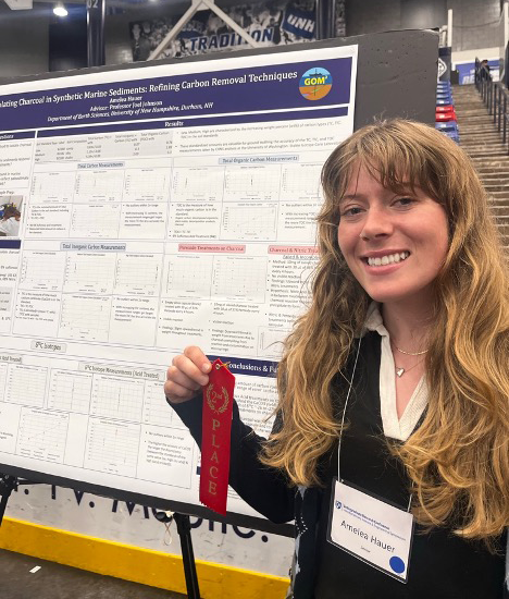 UNH student with research poster