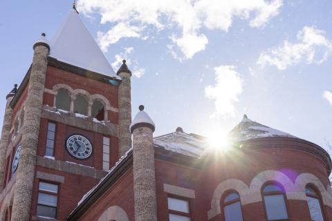 Sun glints off the top of Thompson Hall after a dusting of snow