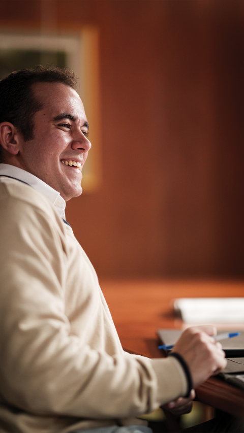 mcd student sitting at a desk smiling
