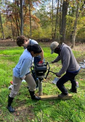 group of ADAPT team members drilling a hole