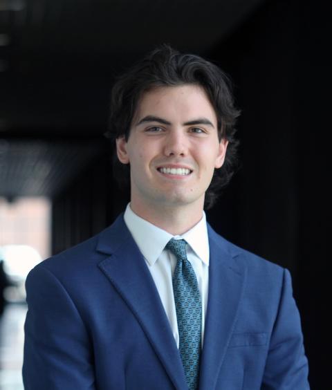 Young man in blue suit smiles at the camera