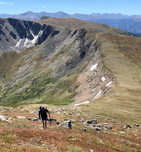 person hiking on a mountain ridge