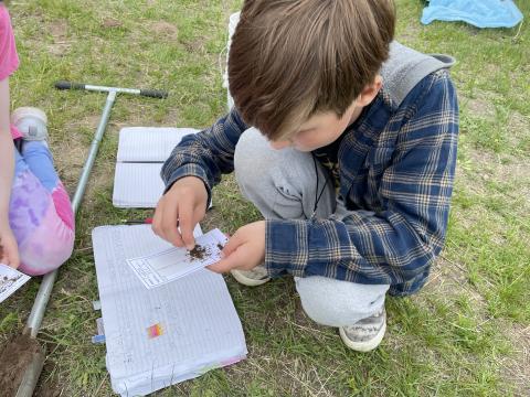 Elementary school student examines soil as part of Earth Around Us tent program.