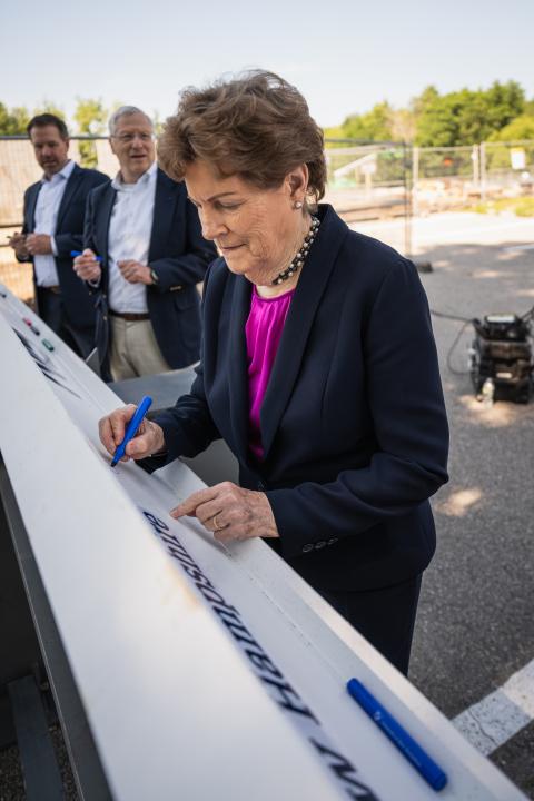 Sen. Jeanne Shaheen signs a construction beam.