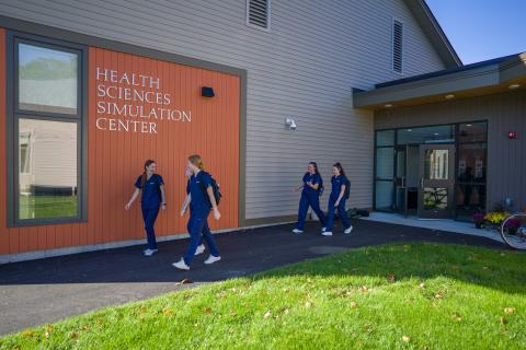 Students walk outside the UNH Health Sciences Simulation Center.