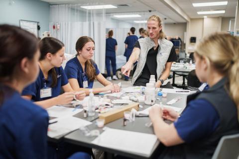 Students from multiple disciplines debrief at the UNH Health Sciences Simulation Center.&nbsp;