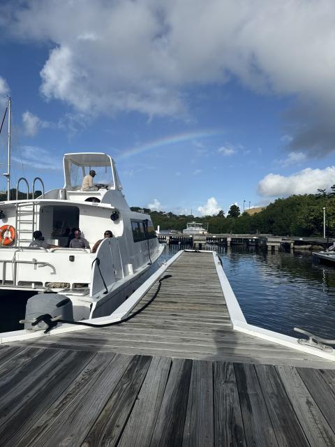 A Lovango Resort & Beach Club boat docked at a marina beneath a rainbow in the U.S. Virgin Islands.