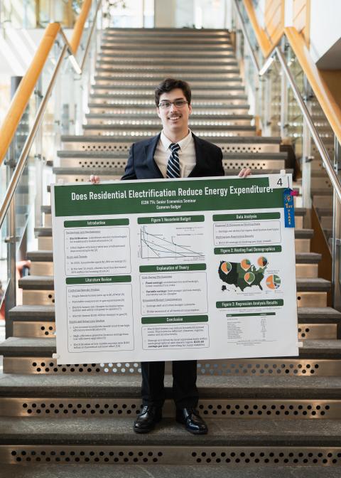 Cameron Badger stands with first-place poster