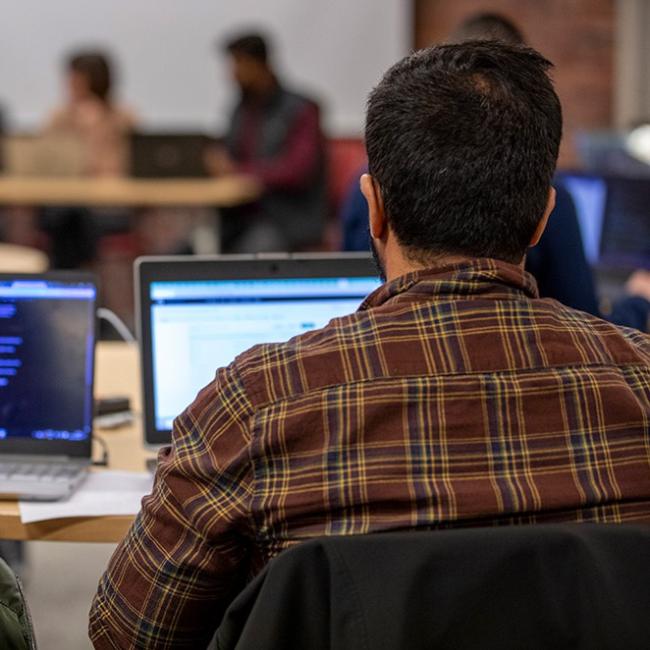 Male student sitting and facing his computer