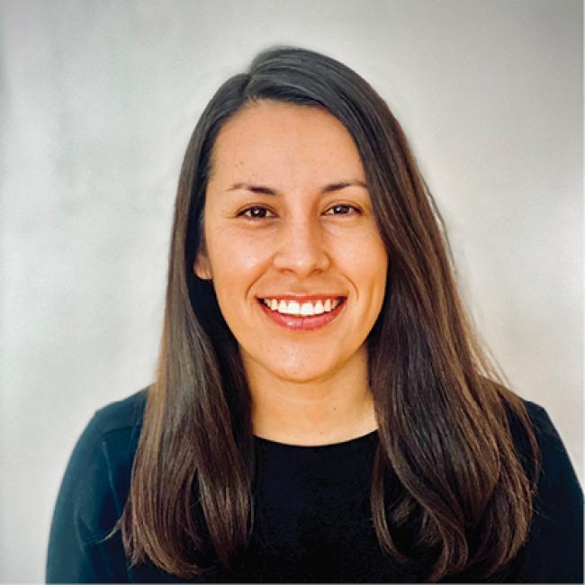 Woman smiling at the camera while wearing a green shirt