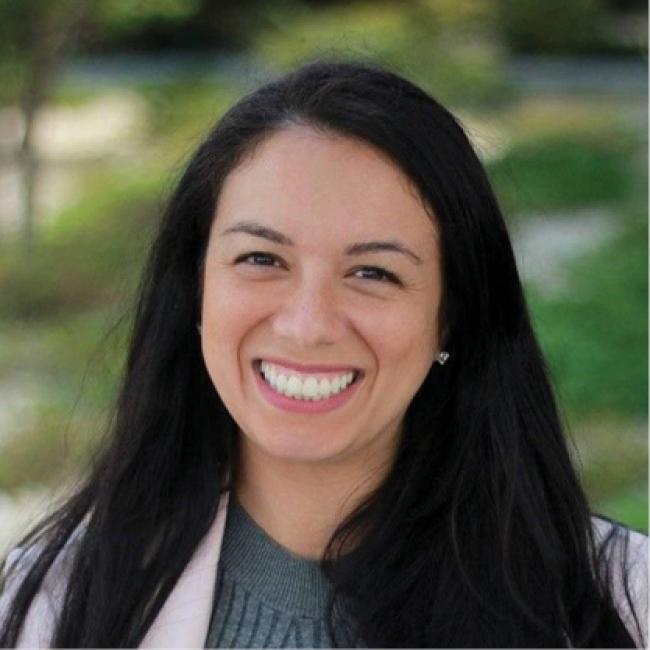 female with black hair smiling